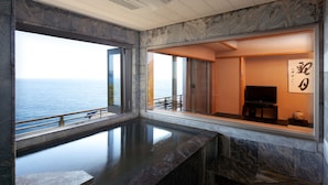 A spa room with a large window overlooking the sea, a marble floor, and a television. - Kissho CAREN (Higashiizu)