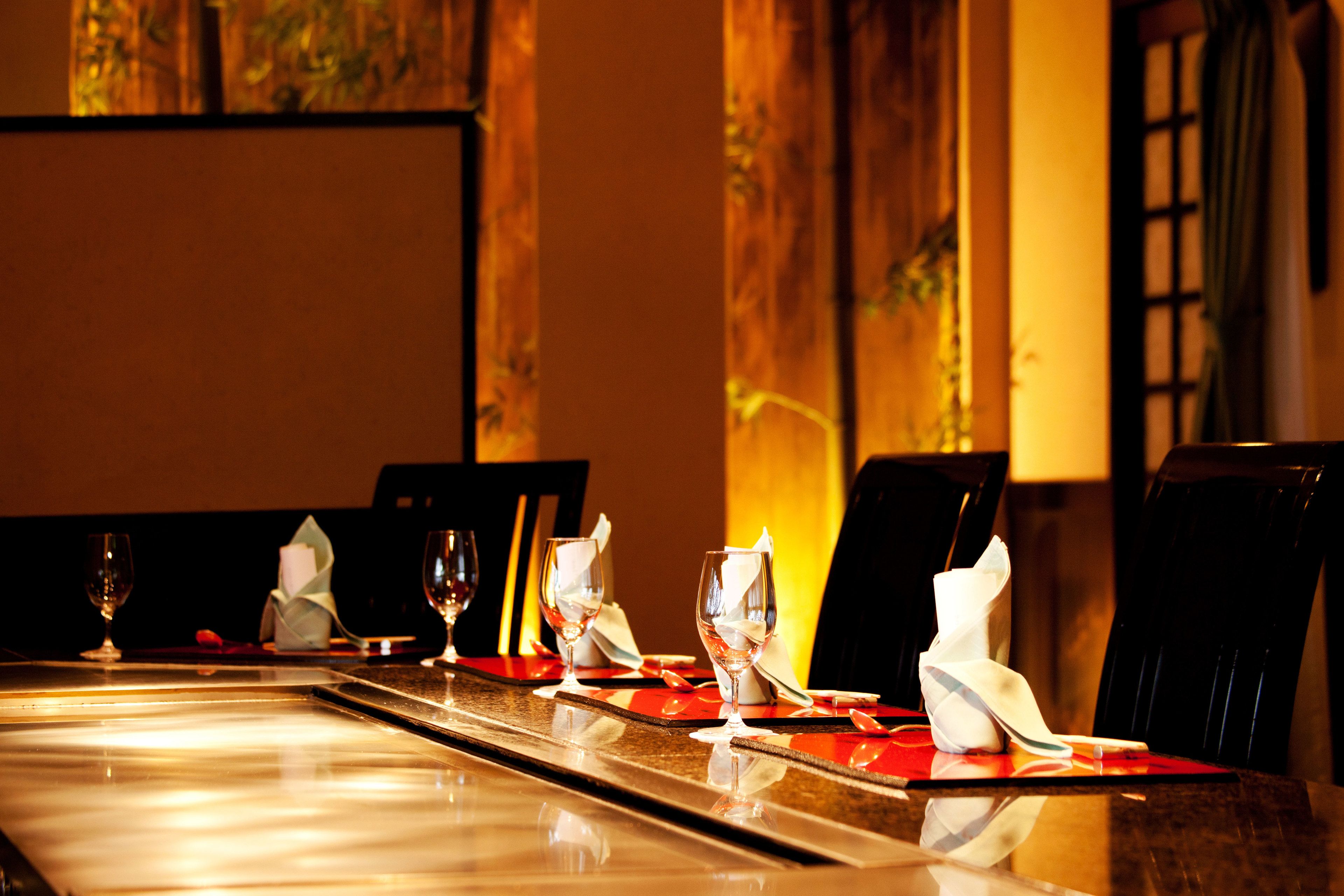 A conference table with chairs, glasses, and napkins set for a meeting.