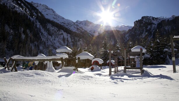 A snow-covered outdoor area with a wooden structure and a clear view of snow-capped mountains in the background. - Kinder- & Gletscherhotel Hintertuxerhof (Tux)