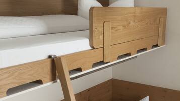 A bunk bed with a wooden headboard and white bedding.
