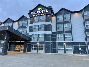 A Microtel by Wyndham hotel with a modern design, featuring a prominent entrance and multiple windows. - Microtel Inn & Suites By Wyndham Whitecourt (Whitecourt)