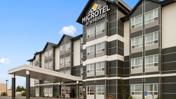 Un hotel Microtel by Wyndham con fachada moderna, ventanas amplias y entrada cubierta.