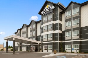 A Microtel by Wyndham hotel with a modern facade, large windows, and a covered entrance. - Microtel Inn & Suites By Wyndham Whitecourt (Whitecourt)