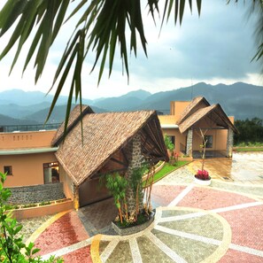 Experience the charm of our thatched-roof resort, surrounded by lush mountains and a vibrant courtyard with a variety of tiles.