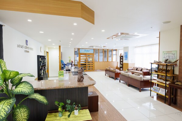 Vestíbulo de hotel con mostrador de recepción, zona de estar y exhibición de artesanías locales.