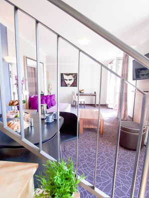 A modern hotel room with a staircase, a dining area, and a living space. - 24hours Apartment Hotel (Vienna)