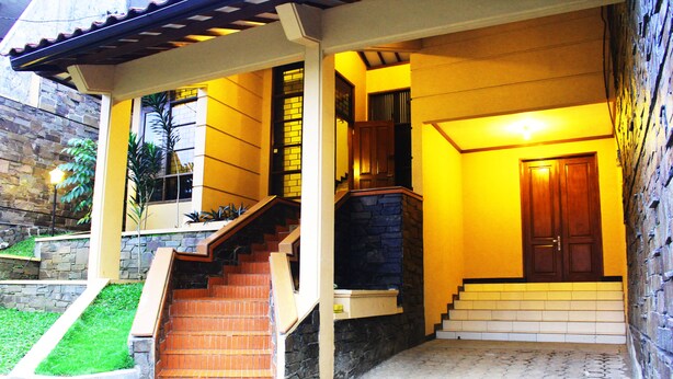 A house with a stone exterior, a wooden staircase, and a door. - De Orange Pasteur Guest House by HouseinBandung (Bandung)