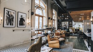 A spacious library with high ceilings, large windows, and a variety of seating areas. - Market House - An Atlas Boutique Hotel (Tel Aviv)
