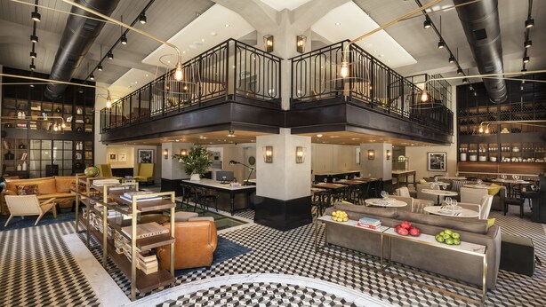A spacious hotel lobby with a high ceiling, a mezzanine level, and a variety of seating areas including sofas and tables. - Market House - An Atlas Boutique Hotel (Tel Aviv)