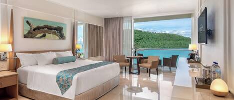 Ein Hotelzimmer mit Bett, Schreibtisch, Stuhl, Tisch und Meerblick.