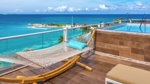 A hammock with a cushion, a bench, and a view of the ocean. - Moon Palace Jamaica – All Inclusive (Ocho Rios)