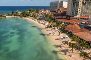 On the beach, white sand, sun loungers, beach umbrellas