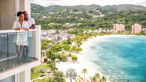 A balcony with a view of a beach and a town. - Moon Palace Jamaica – All Inclusive (Ocho Rios)