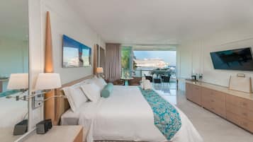 Camera d'hotel moderna con un letto grande, una TV e un balcone con vista su una nave da crociera.