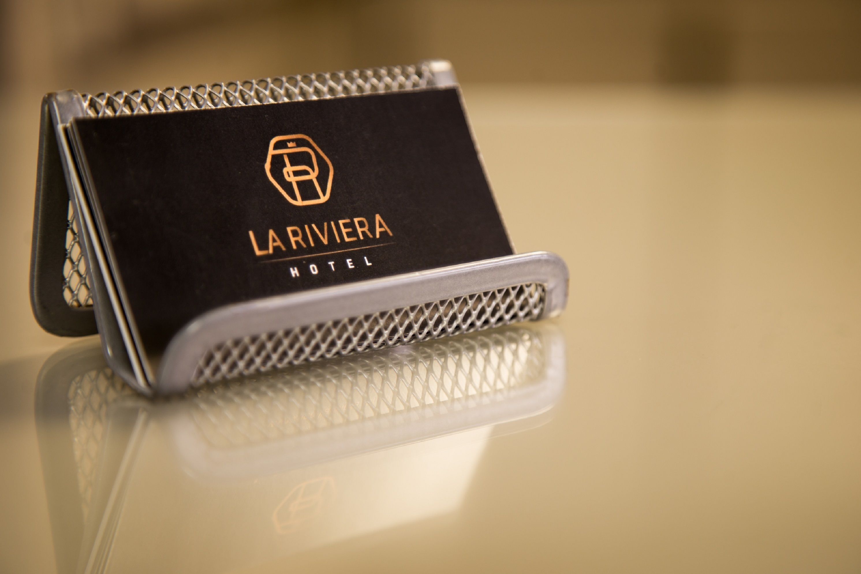Musta käyntikortti, jossa lukee ”LA RIVIERA HOTEL” ja on hotellin logo.