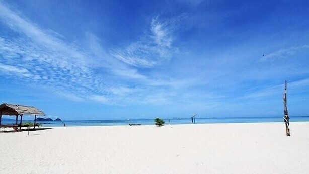 A beach with a clear sky, a few people, and a small structure. - Seaview Rainbow (Ko Pha-ngan)