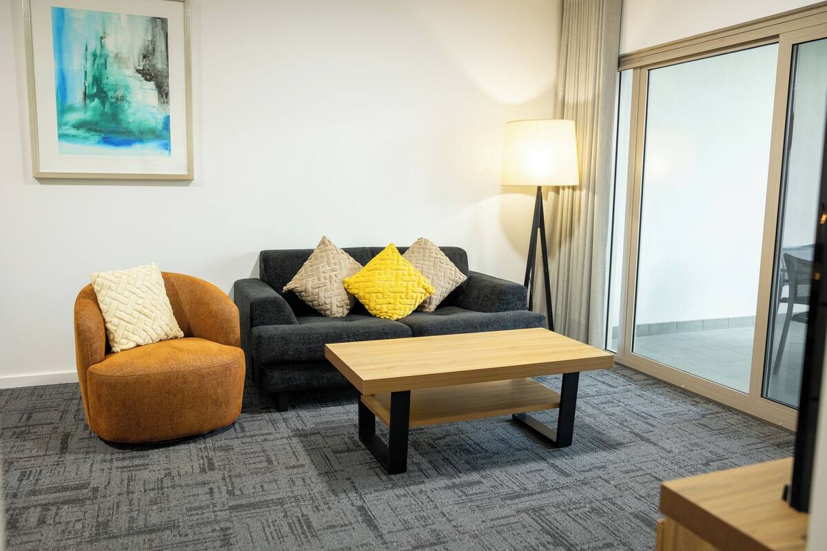 A modern living room with a sofa, armchair, and a coffee table.