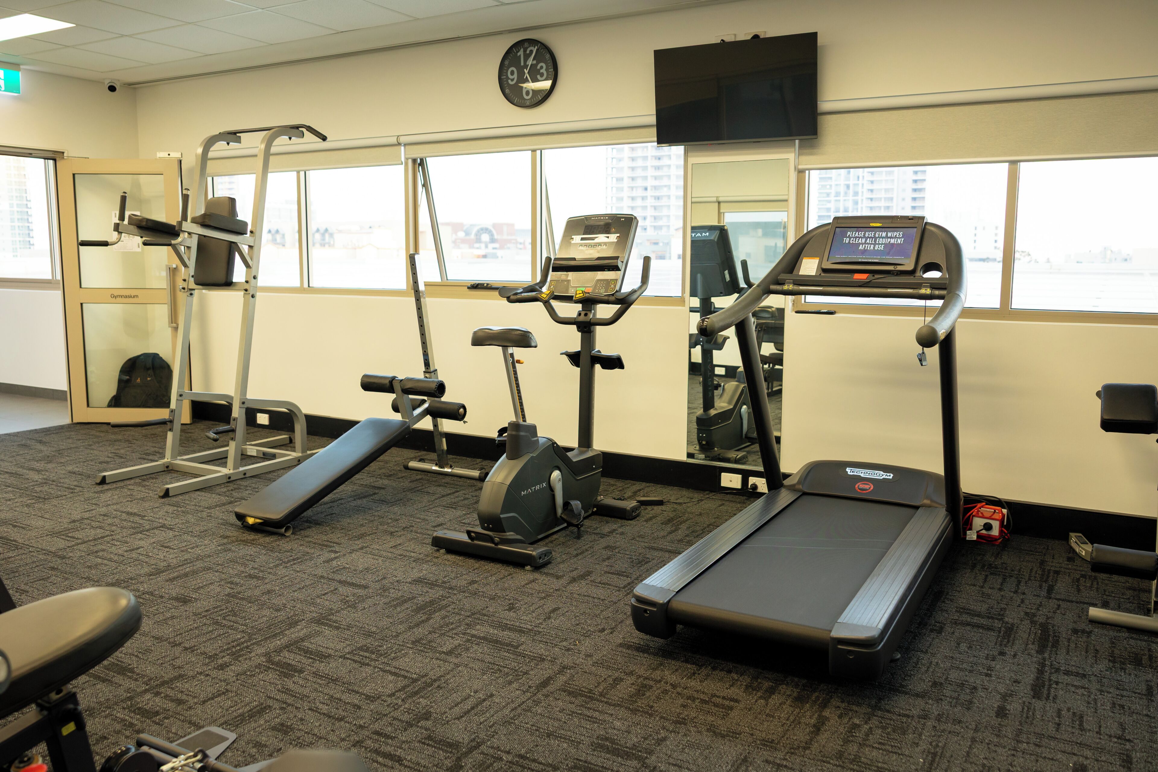 Ein Fitnessstudio mit Laufbändern, Crosstrainern und Steigern.
