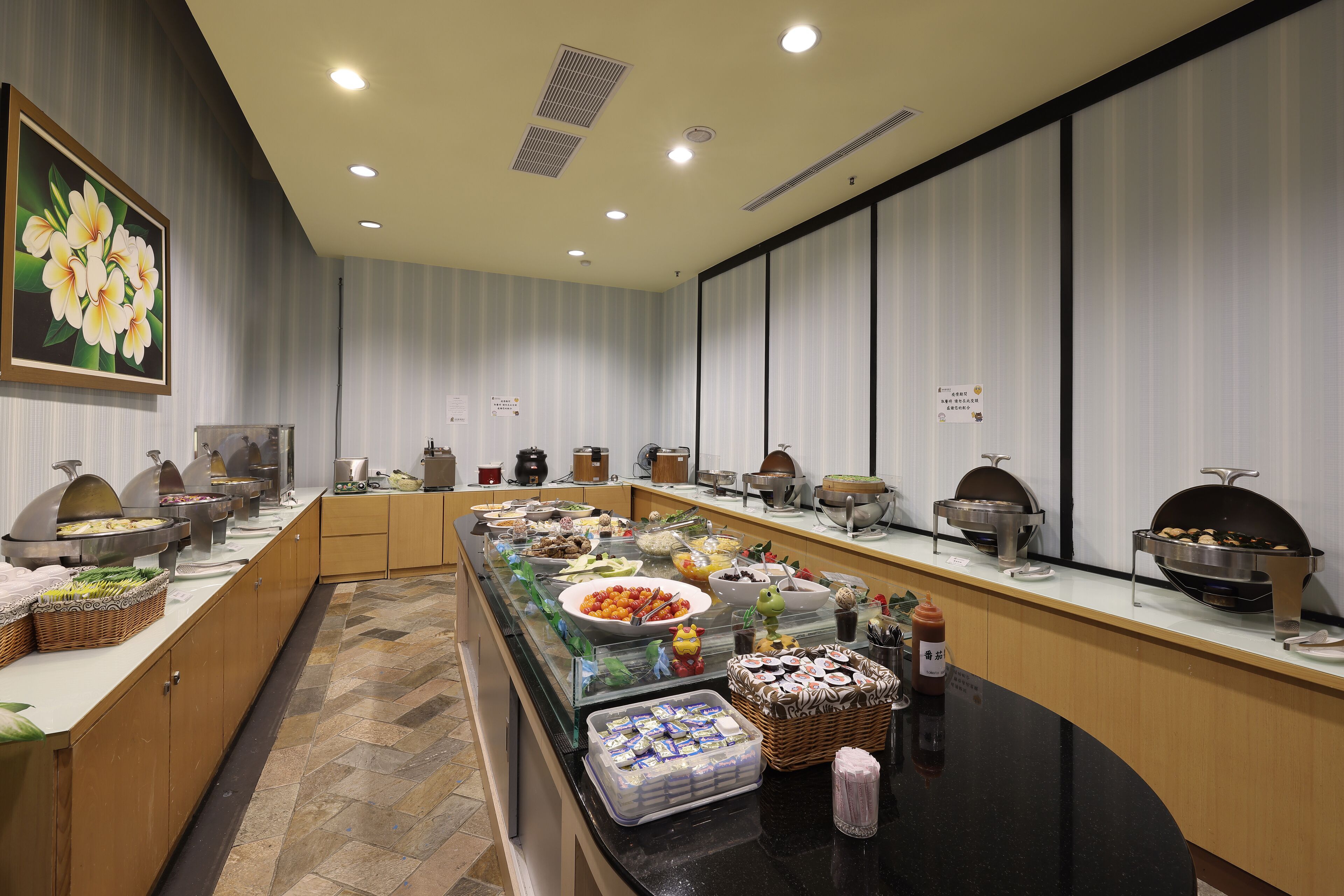 Un buffet proposant différents plats, avec notamment un assortiment de fruits, des salades et des plats chauds.
