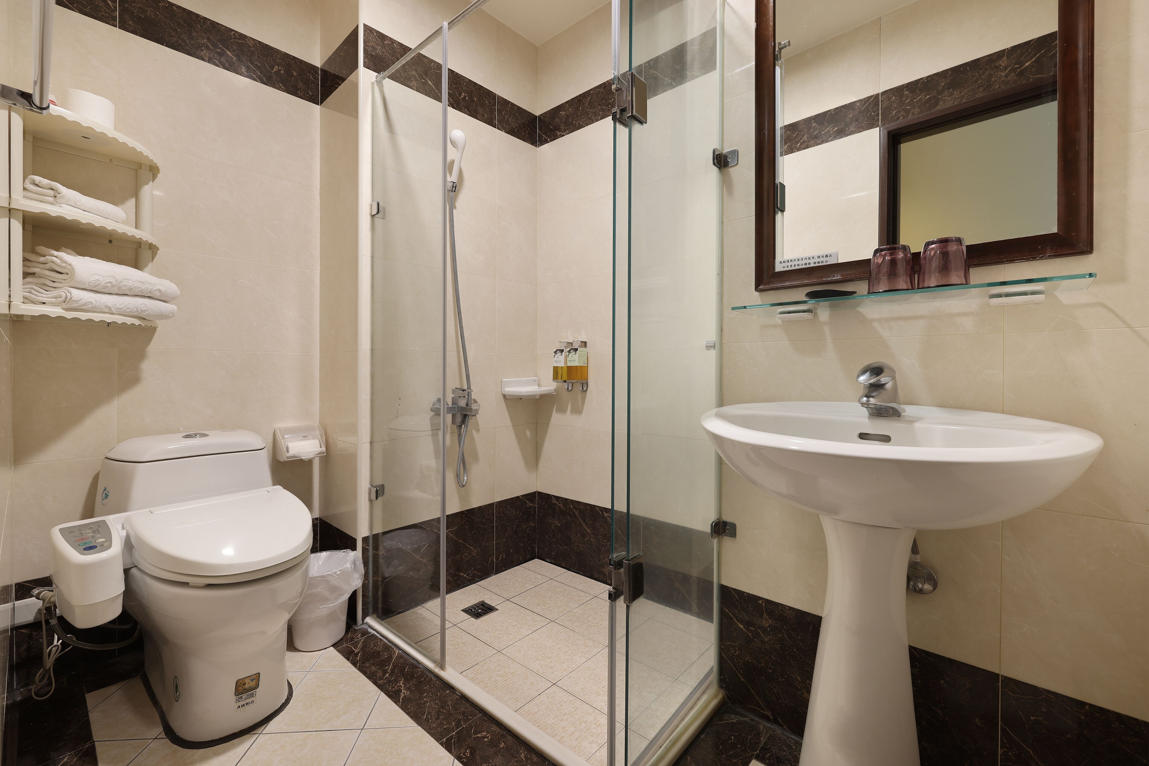 A modern bathroom with a glass-enclosed shower, a pedestal sink, and a toilet.