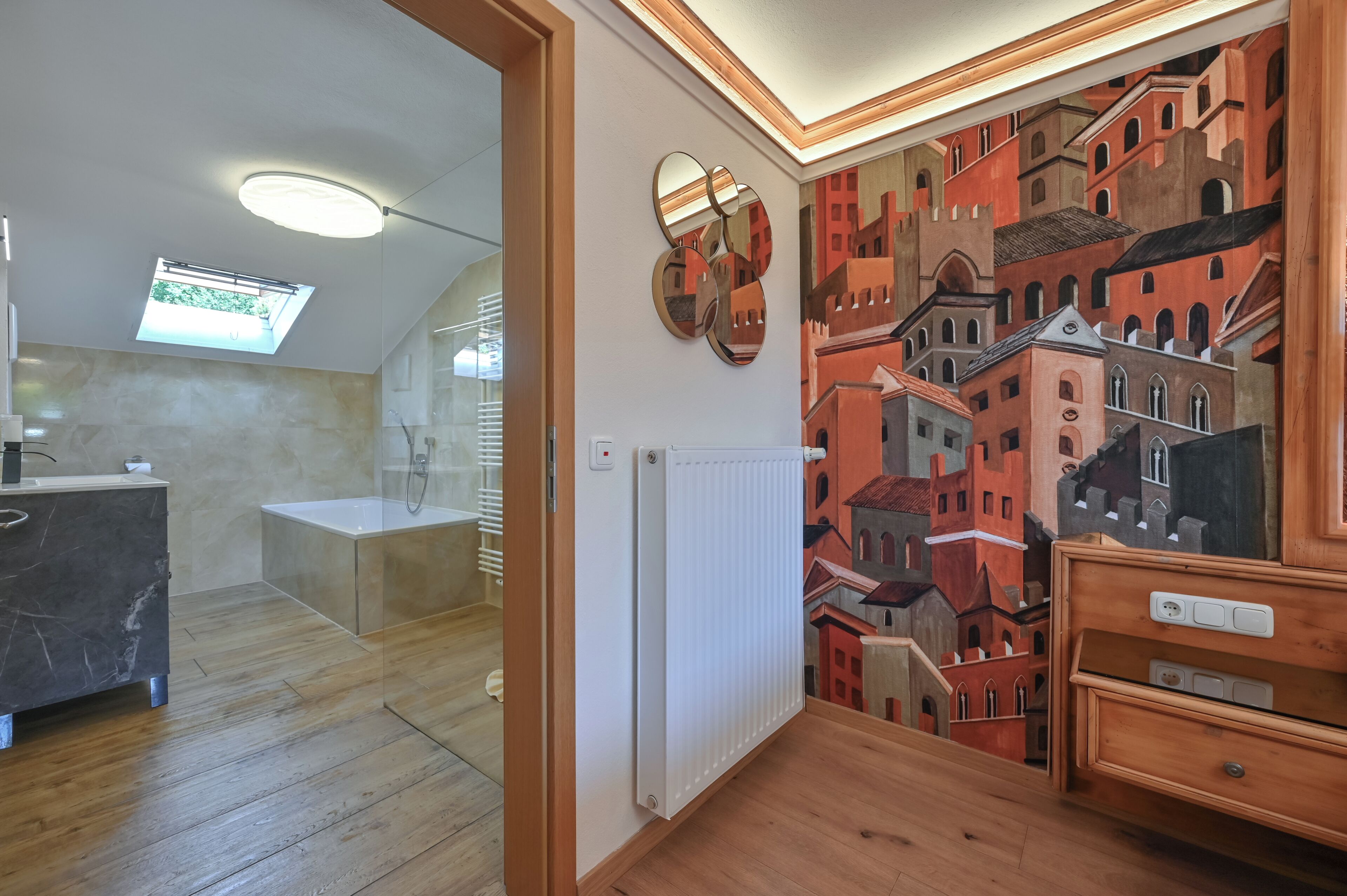 Ein modernes Badezimmer mit Oberlicht, einer Badewanne, einem Waschtisch mit Marmorplatte und einem Holzkasten.