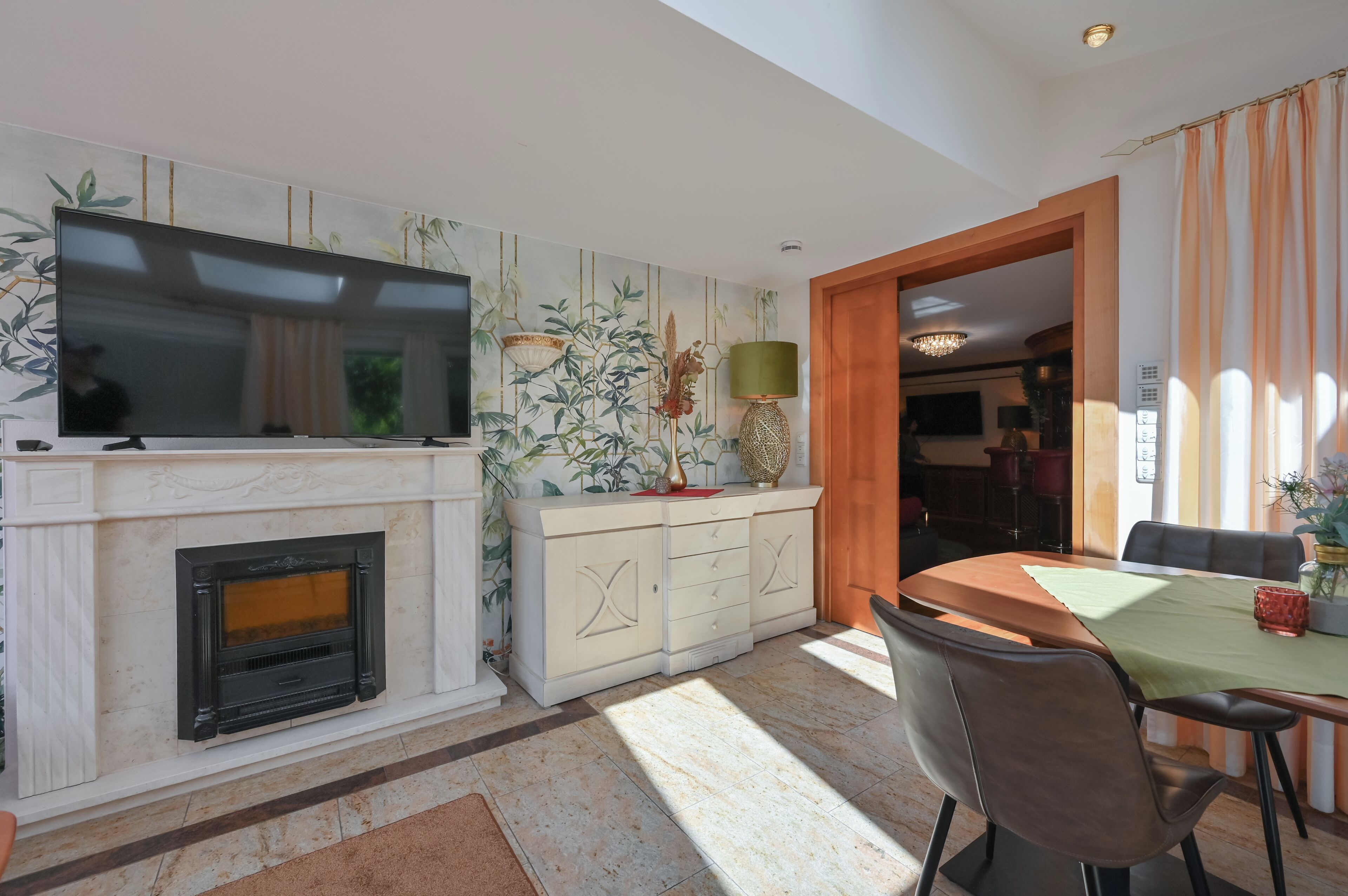 A living room with a fireplace, television, and dining area.