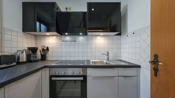 A modern kitchen with a built-in oven, a sink, and a toaster.