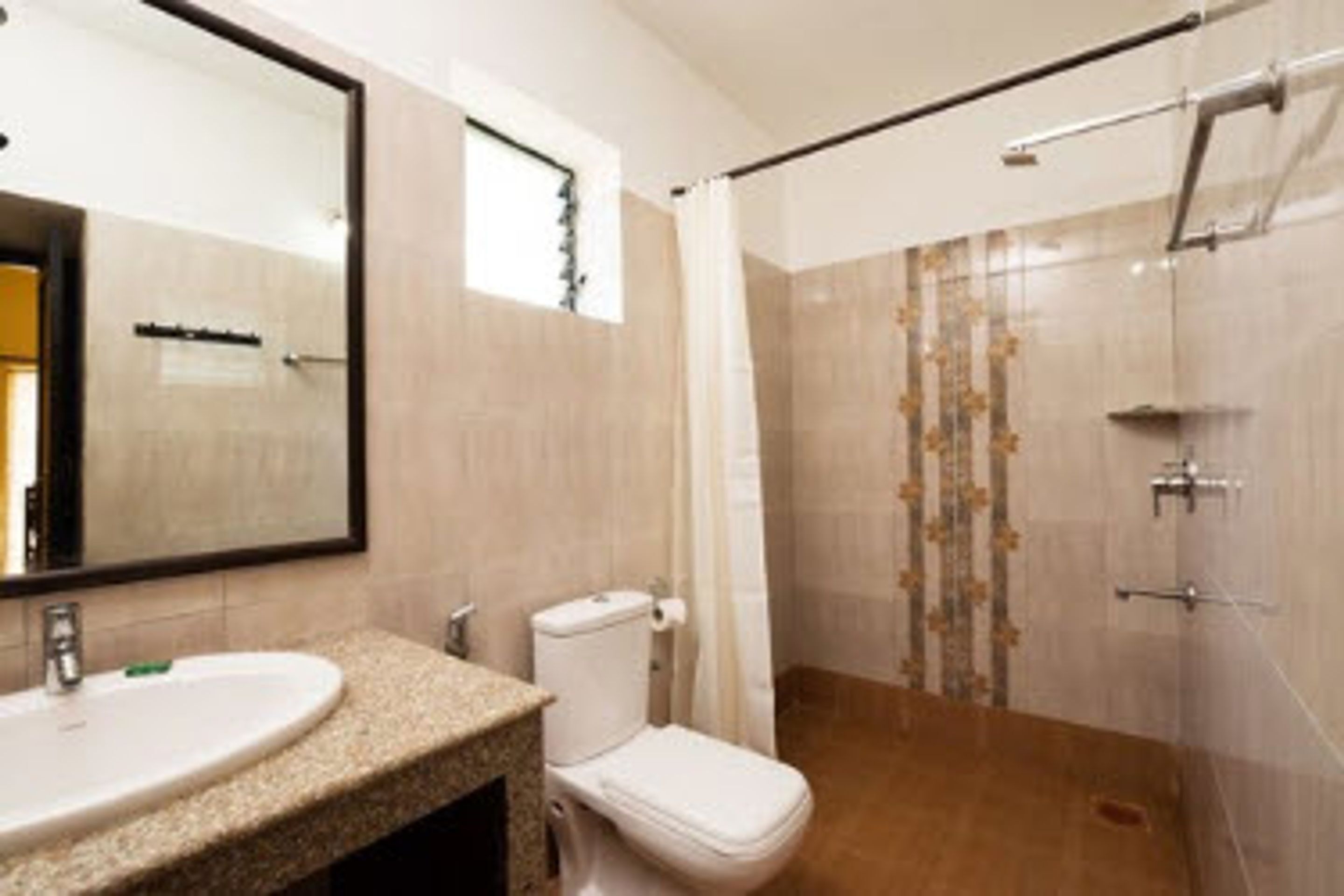 A bathroom with a sink, toilet, and shower area.