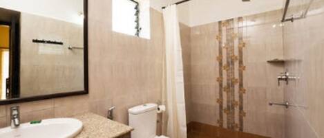 A bathroom with a sink, toilet, and shower area.