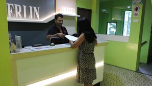 A hotel reception desk with a sign reading "HOTEL" and "ERLIN". - Merlin Hotel (George Town)