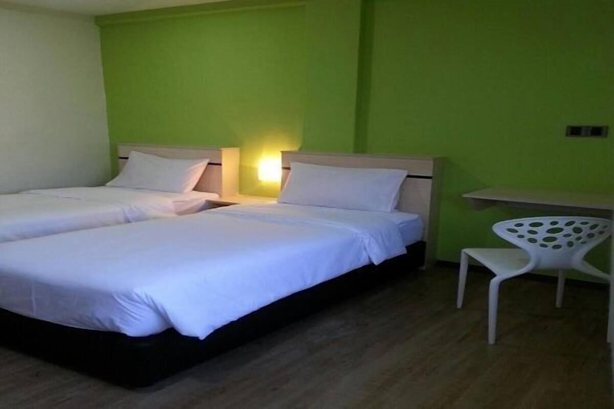 A room with two beds, a desk, and a chair.