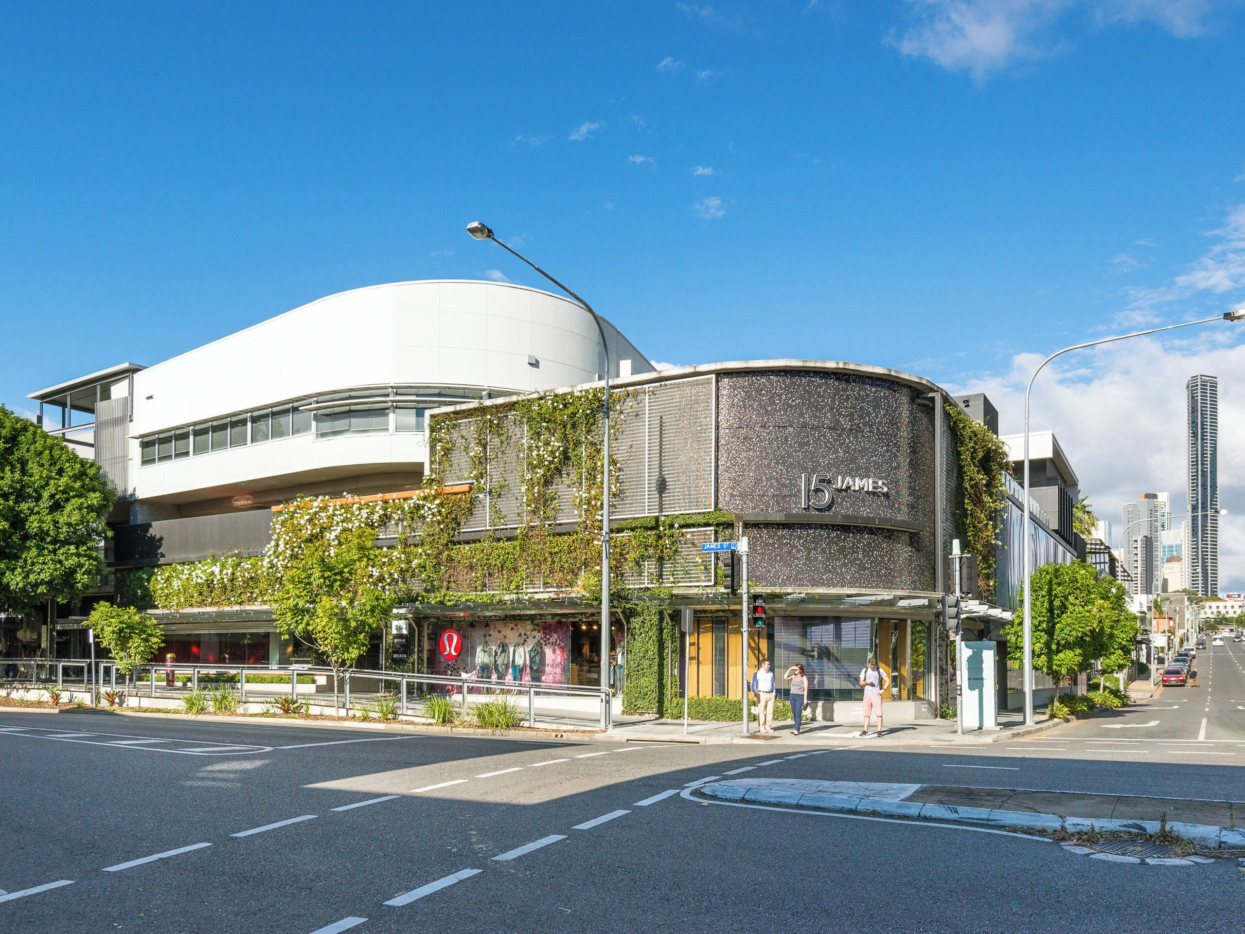 A modern building with a curved facade, a prominent '15 James' sign, and a street view with pedestrians.