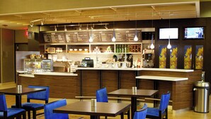 A hotel lobby with a bar area, seating arrangements, and a trash bin.