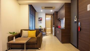 A modern living room with a sofa, a small table, and a potted plant.