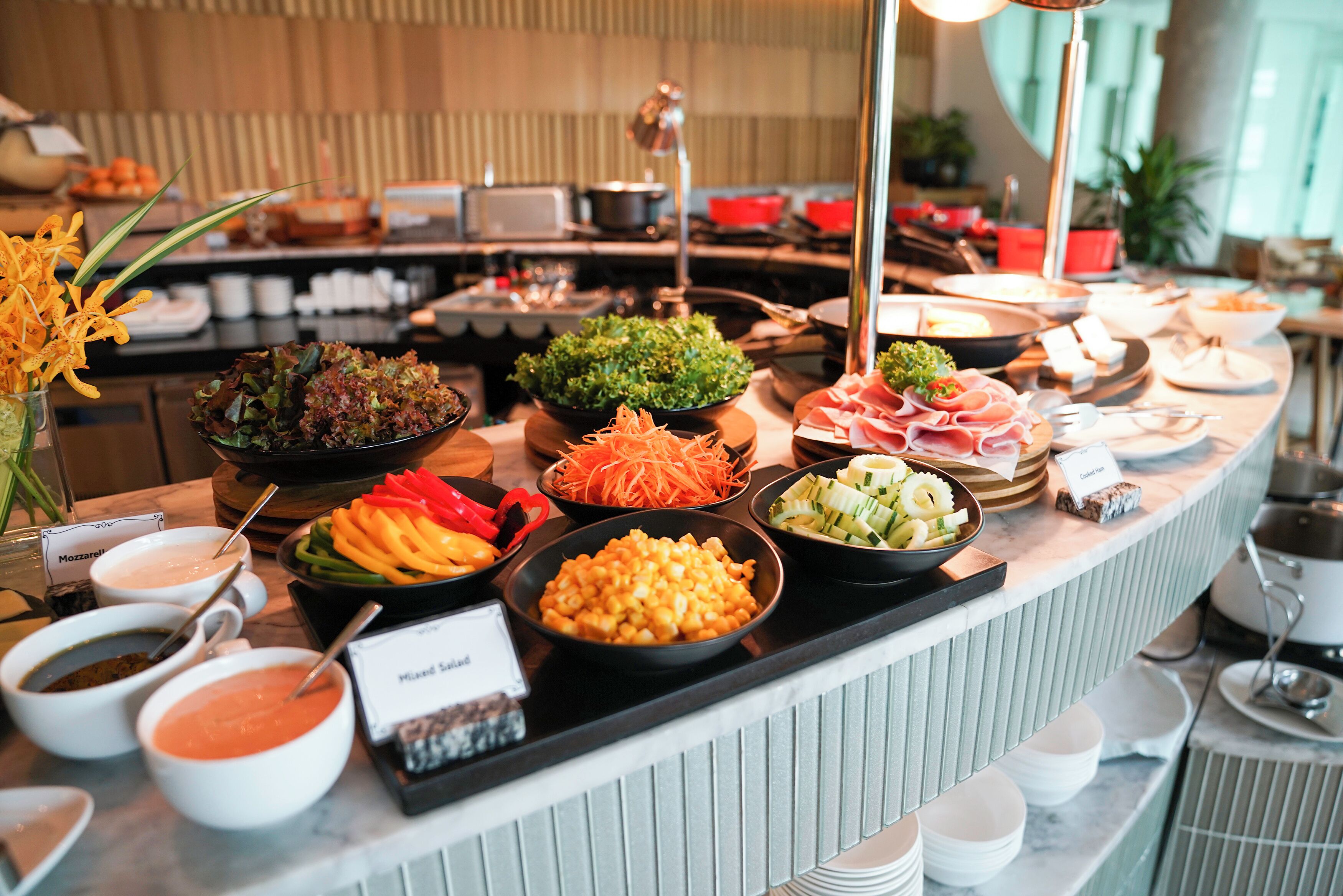 A buffet with various food items including salads, meats, and dips.