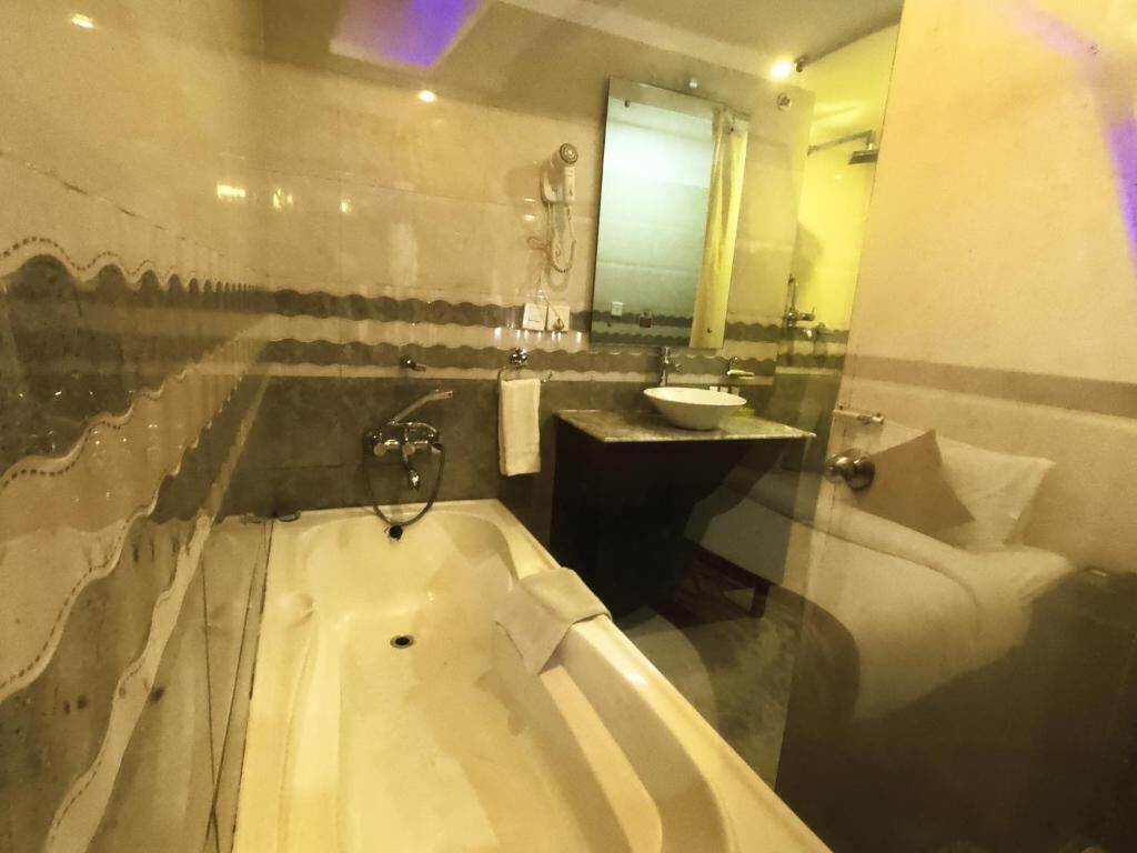 A bathroom with a bathtub, a sink, and a mirror.