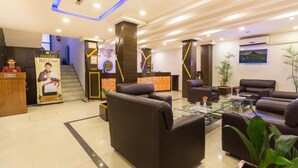 A modern hotel lobby with leather sofas, a reception desk, and a staircase. - Avataar Kathmandu Hotel (Kathmandu)