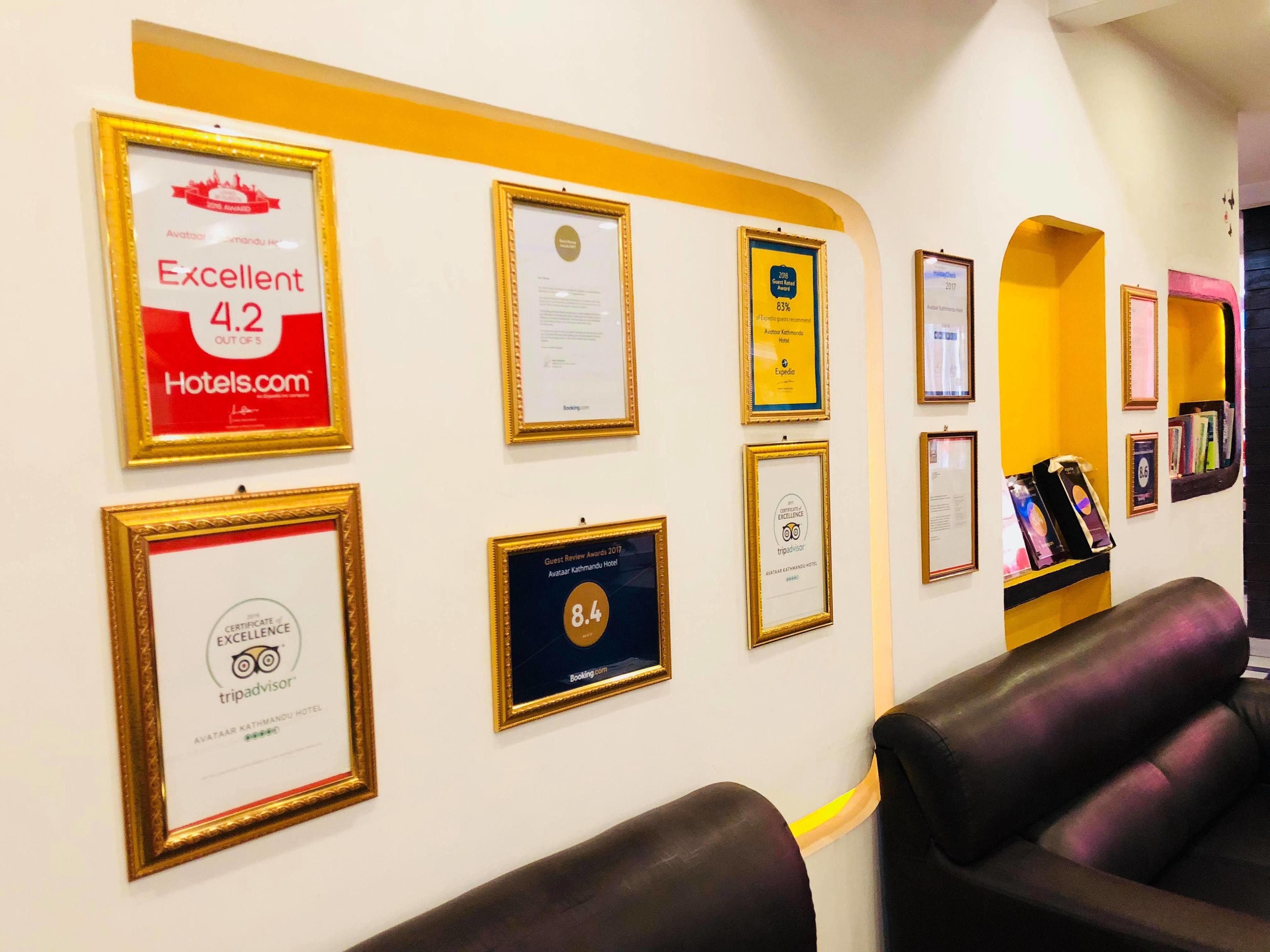 Premios y certificados enmarcados en una pared, incluyendo una calificación de 4.2 de Hotels.com y un premio a la mejor reseña de huéspedes de 2017.