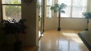 A room with a large window, a potted plant, and a tiled floor. - Happy Valley House (Phoenix)
