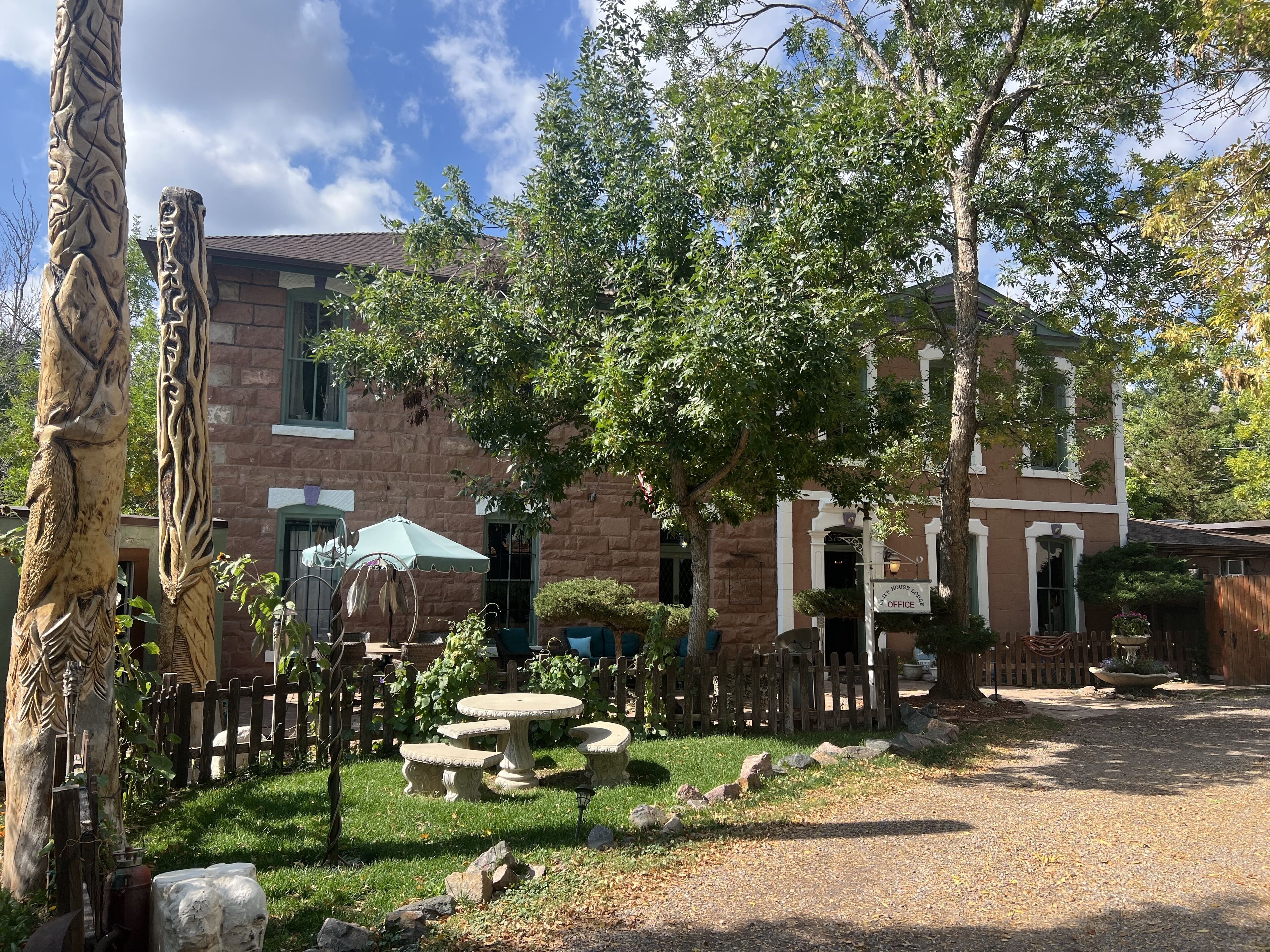 A courtyard with stone benches, a wooden fence, and a building with a sign reading "OFFICE".