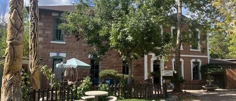 A courtyard with stone benches, a wooden fence, and a building with a sign reading "OFFICE".