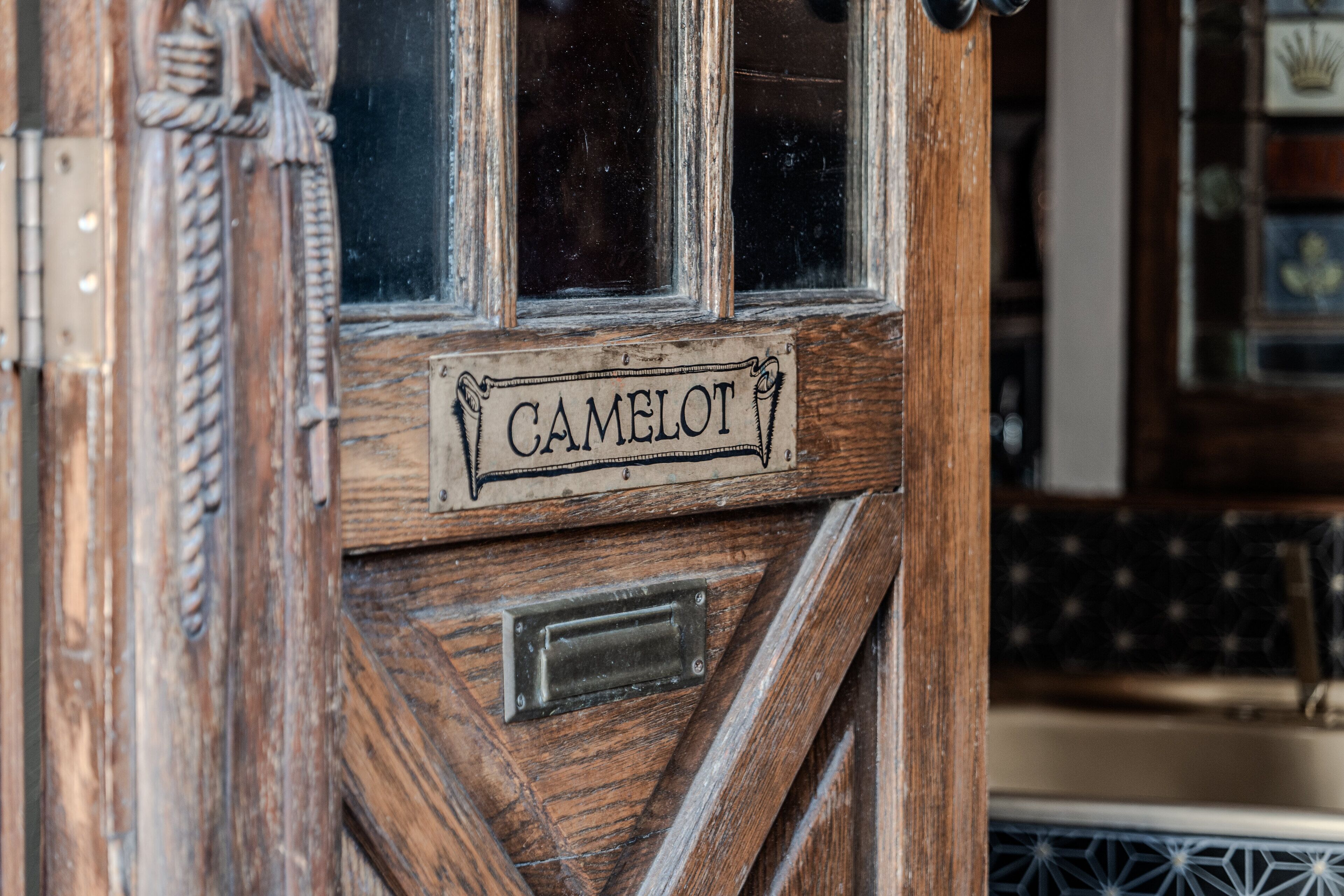 A wooden door with a sign that reads "CAMELOT."