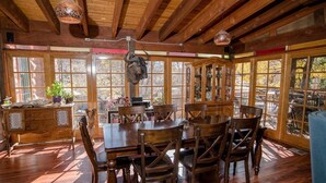 Un comedor rústico con mobiliario de madera y amplias ventanas.