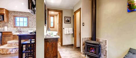 A spacious living area with a stone fireplace, wooden bar, and a cozy seating area.