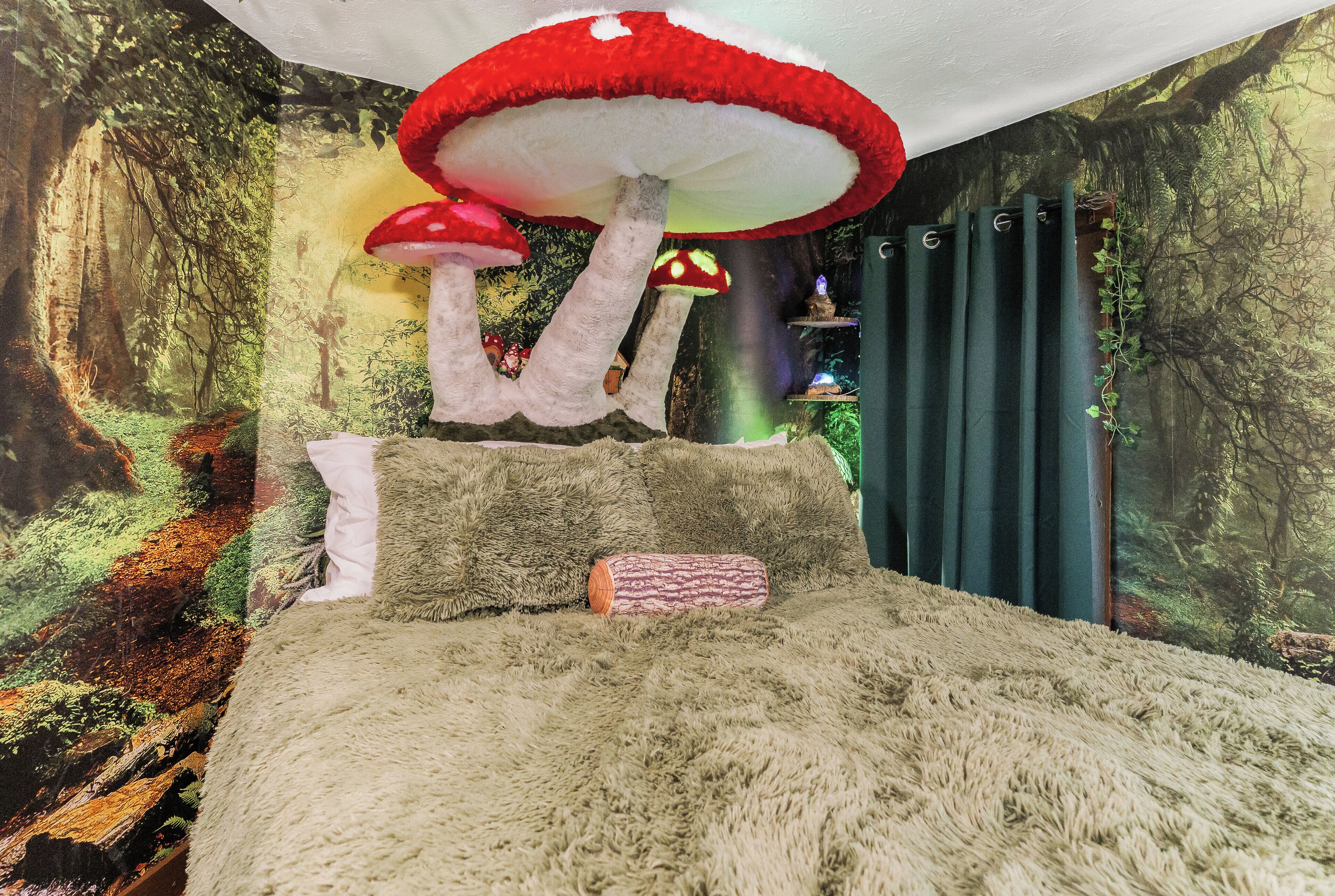 A room with a forest-themed mural, a fluffy beige carpet, and a large red mushroom decoration.