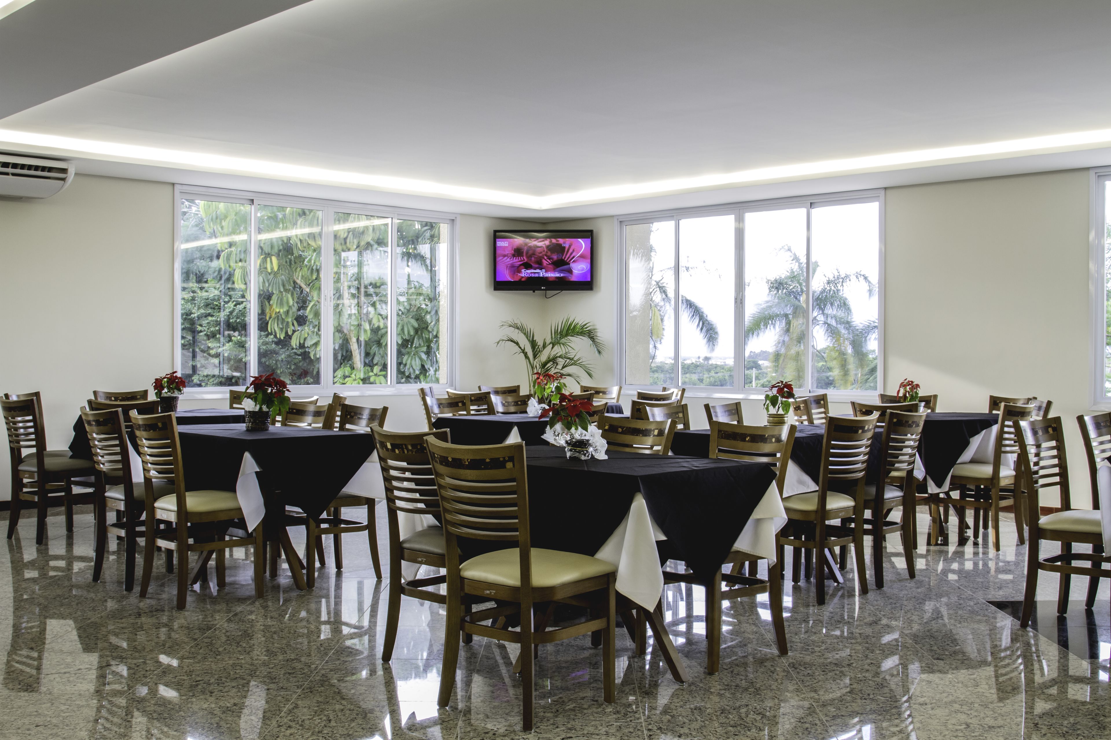 A conference room with a large table, chairs, and a television screen.