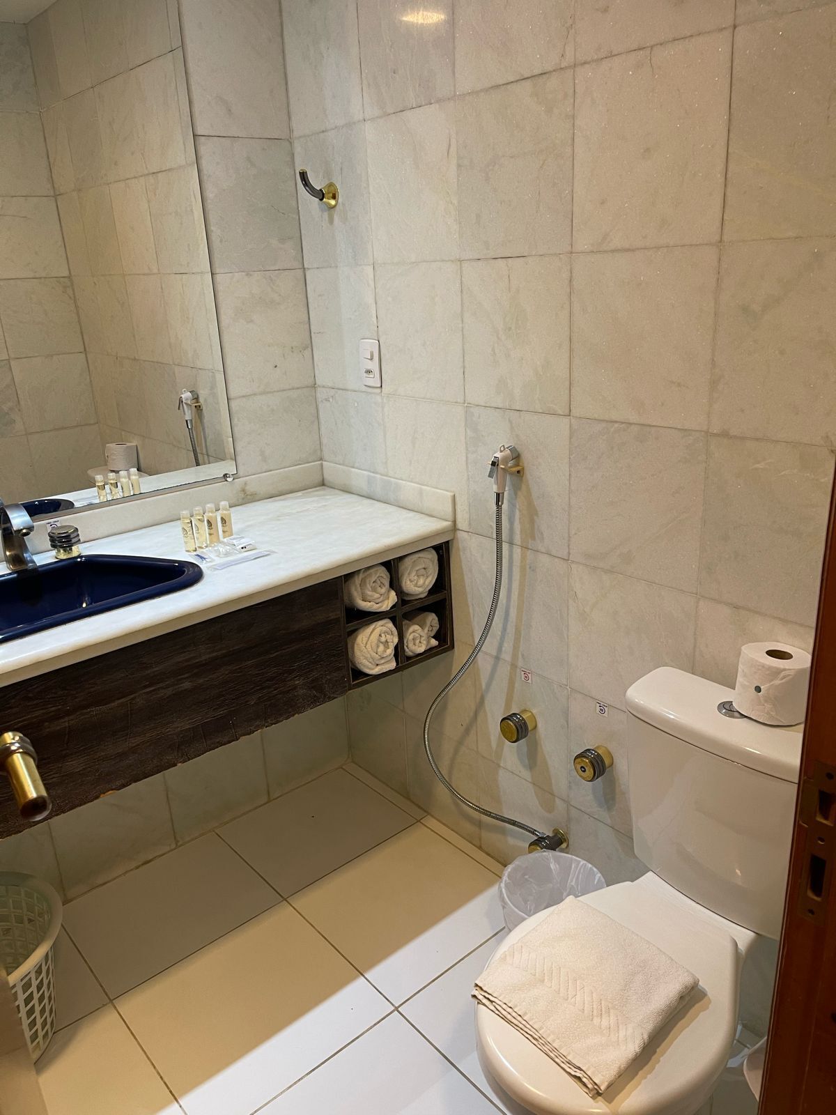 A bathroom with a sink, mirror, towel rack, toilet, and shower.