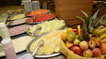 A buffet with various fruits and cheeses.