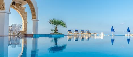 Piscine extérieure, parasols de plage, chaises longues