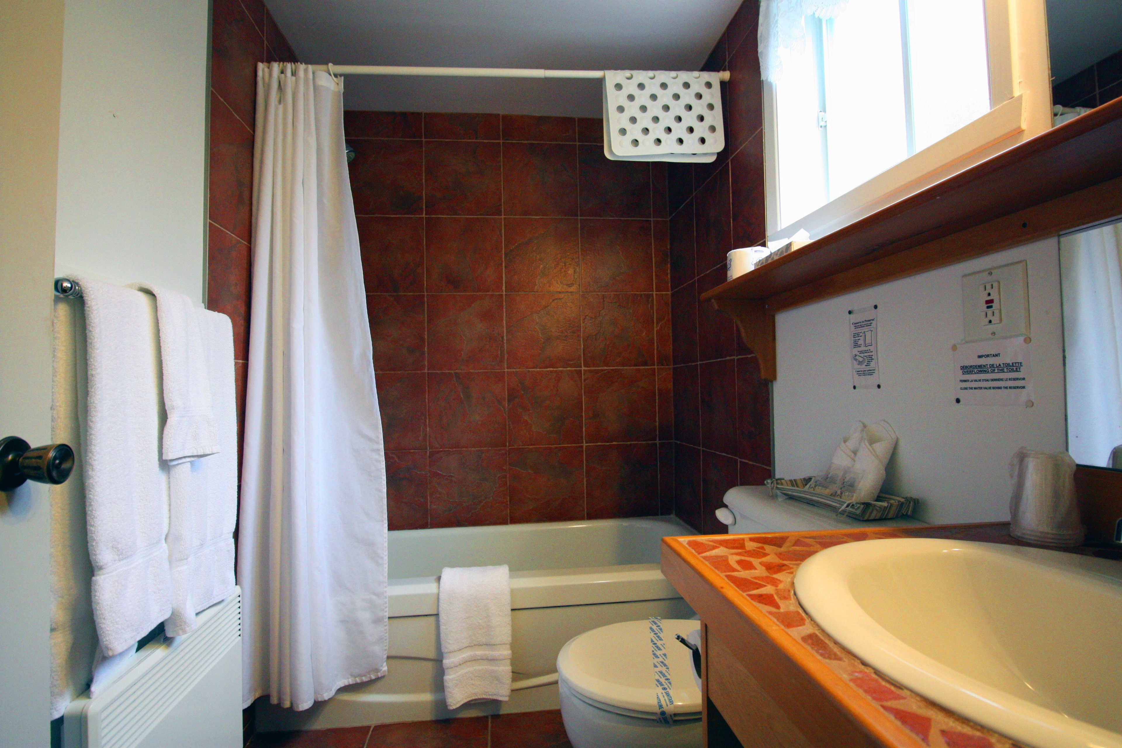 A bathroom with a bathtub, a toilet, and a sink.
